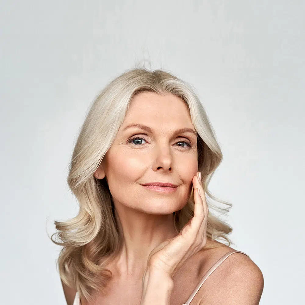 Older woman showing her radiant glowing skin as a result of anti-aging treatment.