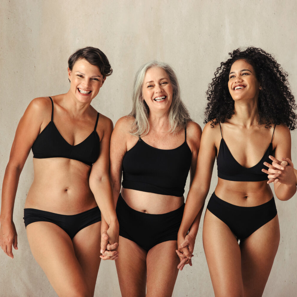3 female models of different ages holding hands in black bikinis